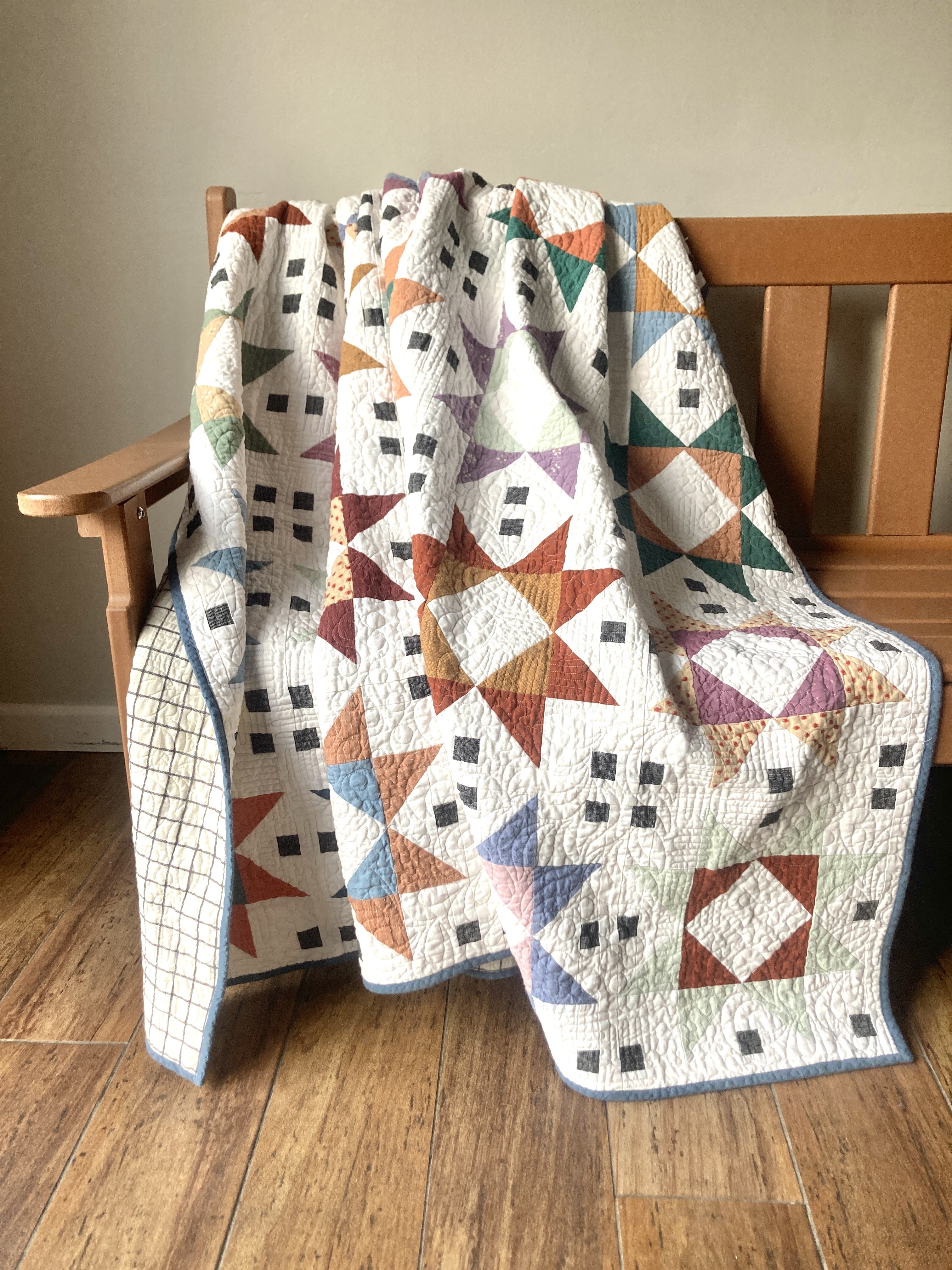 A quilt of tiled star blocks sewn from woven fabrics